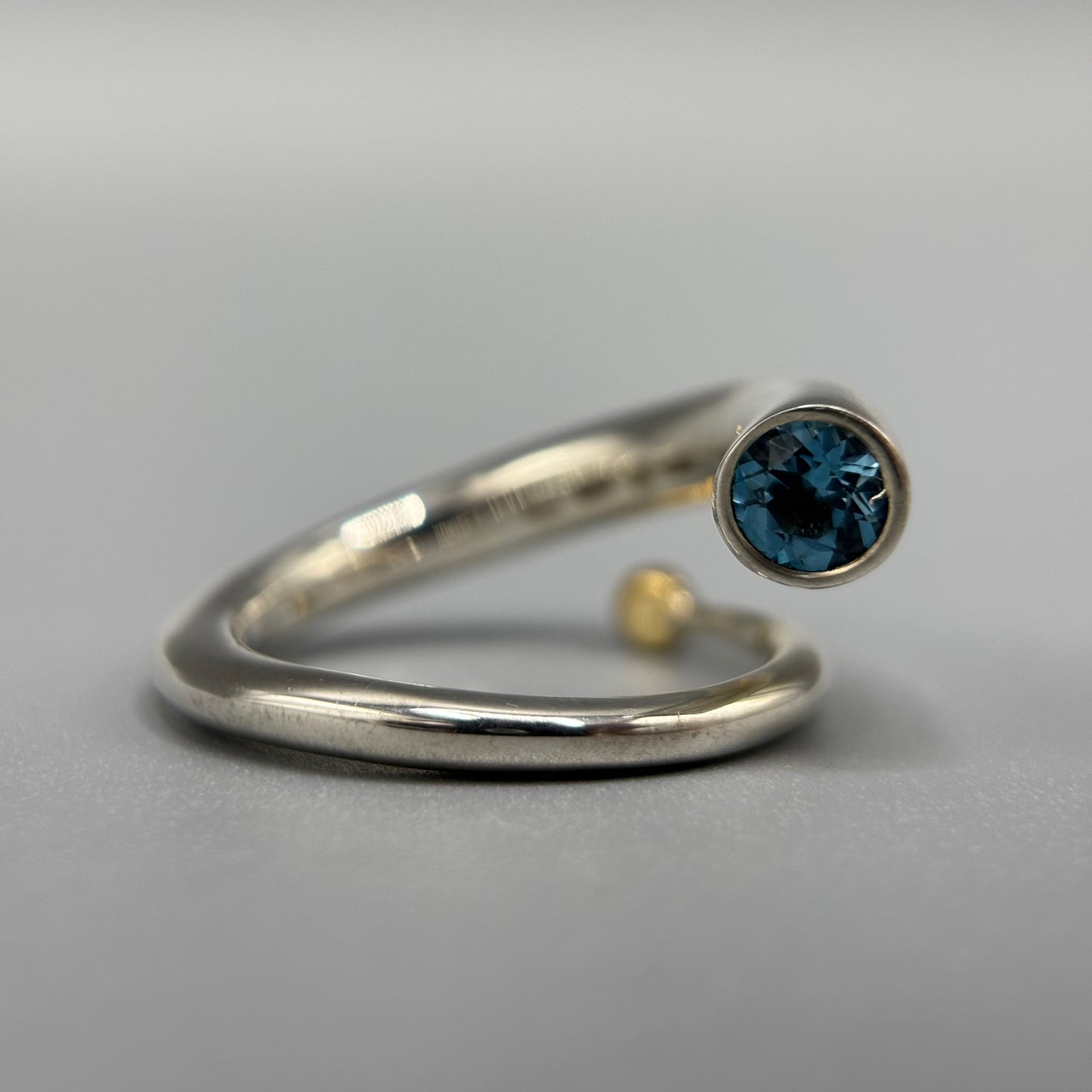 Paul Finch - Ring: Silver spiral with blue topaz & solid 18ct Yellow Gold bead
